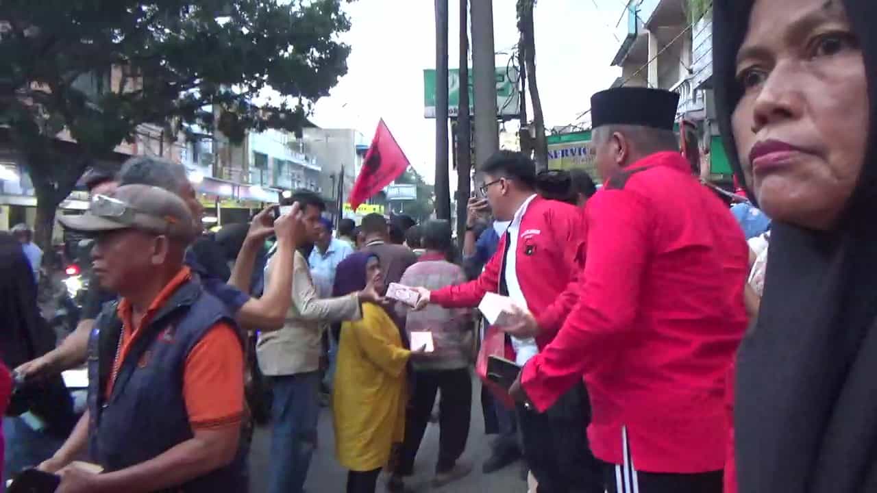Ketua PAC PDI Perjuangan Medan Area, Bobby C. Halim, S.H., M.H., CPM, bersama pengurus PAC dan ranting membagikan takjil kepada pengendara dan pejalan kaki di depan Hotel TravelBiz, Jalan Sutrisno, Medan, Senin (24/3/2025). (Foto: Aris/pelitaharian.id).